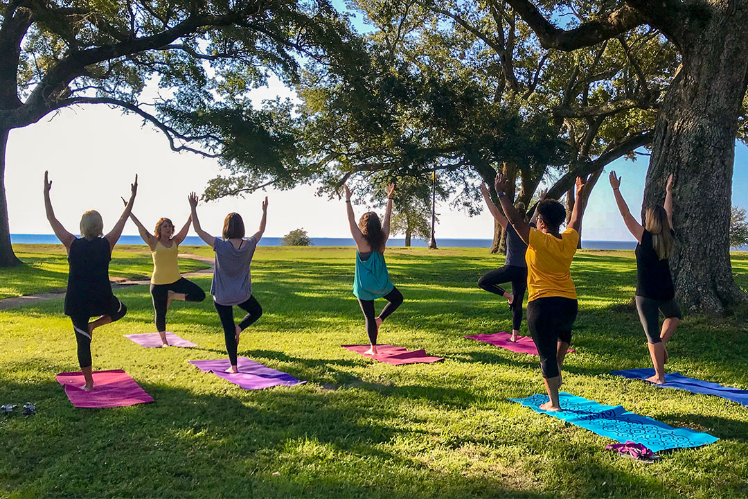 Students practicing yoga on campus near the beach